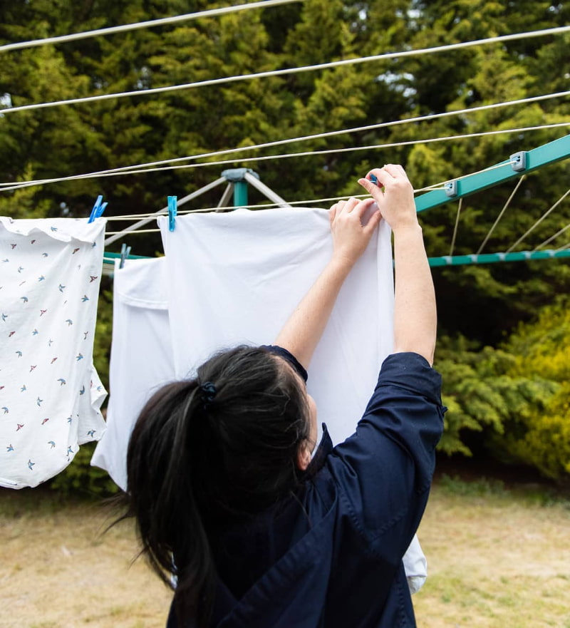 hanging clothes on umbrella clothes dryer