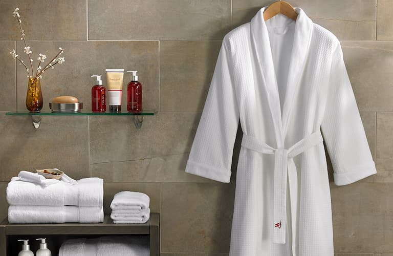 white bathrobe with collar hanging in a bathroom