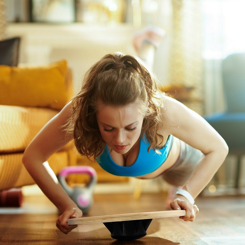 picture of a woman working out at home with a balance board