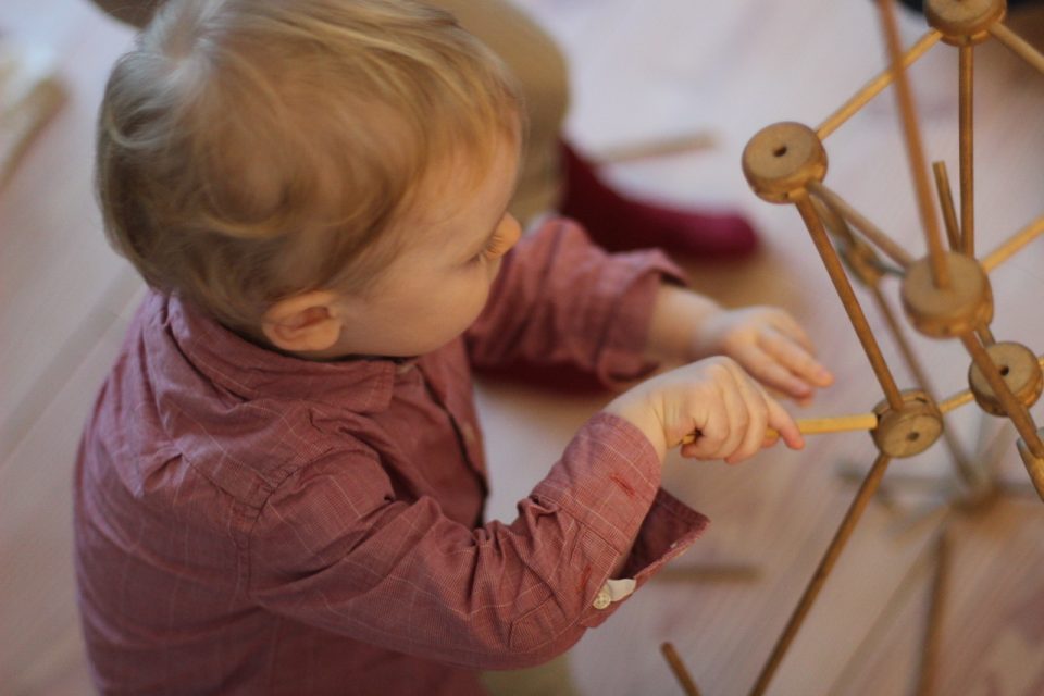 kid playing with wooden toy for kids