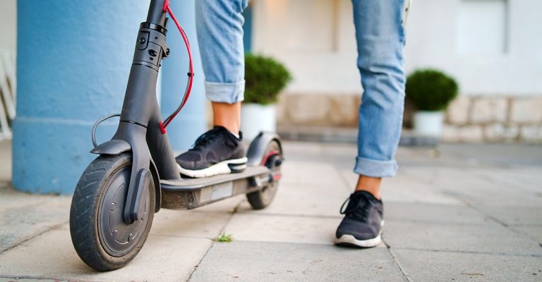 scooter on street and a person standing on it