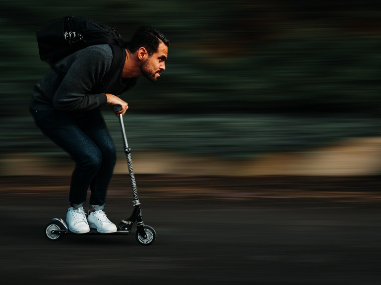 a boy driving kick scooter very fast