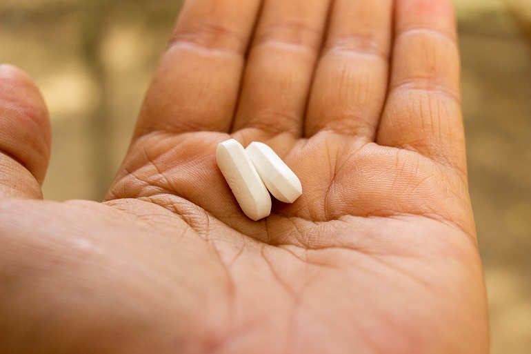 picture of a hand holding two pills