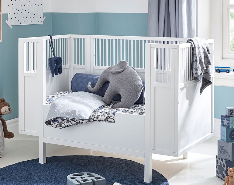 picture of a baby blue room with baby cot and baby toys 