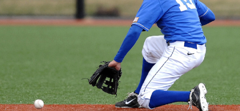 Man playing baseball and going after the ball with his baseball glove