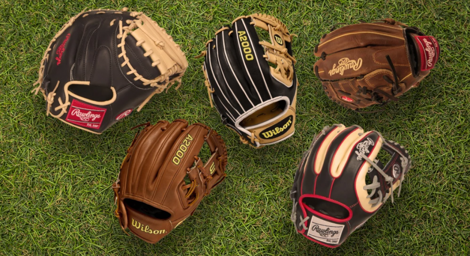 Different kinds of baseball gloves on the grass