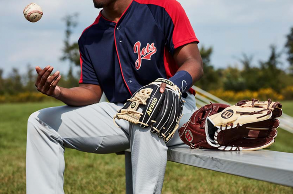 Man wearing a baseball glove and playing with the ball