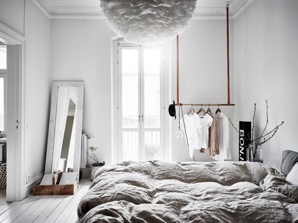 a-quirky-and-airy-Scandinavian-bedroom-with-a-mirror-in-a-frame-railing-for-clothes-a-paper-ruffle-lamp-and-grey-bedding-960x719.jpg