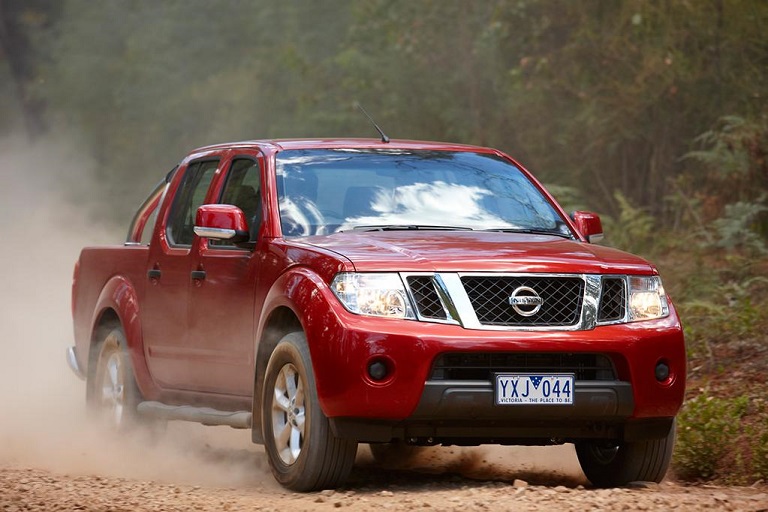 Red Nissan Navara D40 driven in nature.