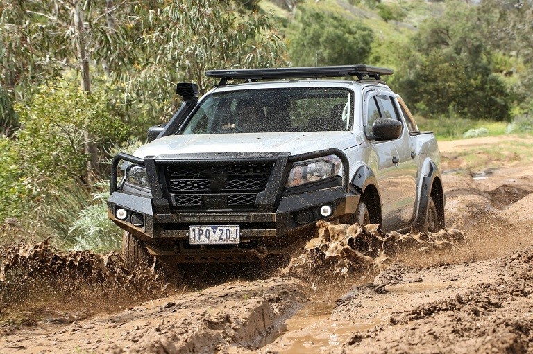 Silver Nissan Navara D40 driven in nature in mud