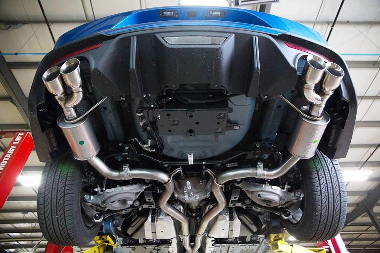 409 stainless steel exhaust system on a blue car in mechanic garage