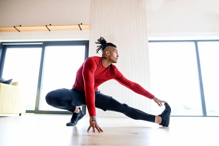 man stretching in his home