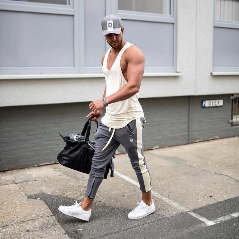 man heading to the gym with his gym bag and a gym outfit on