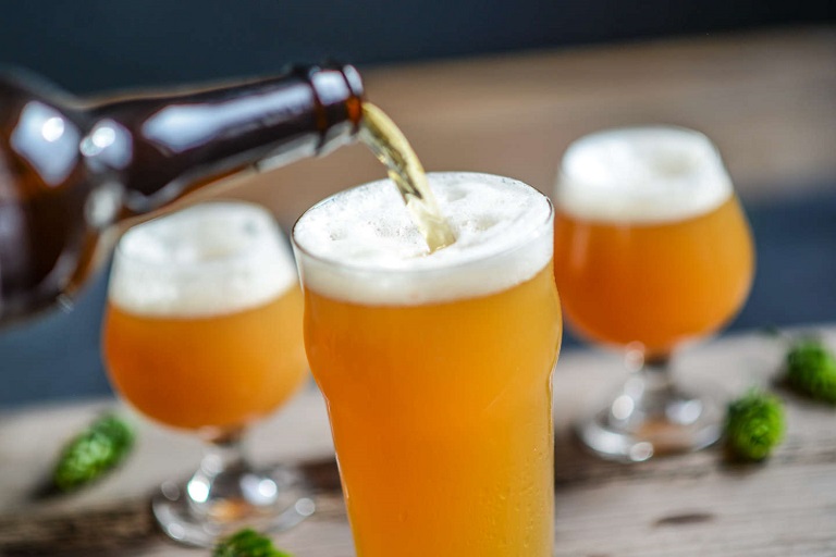 man pouring hazy ipa beer