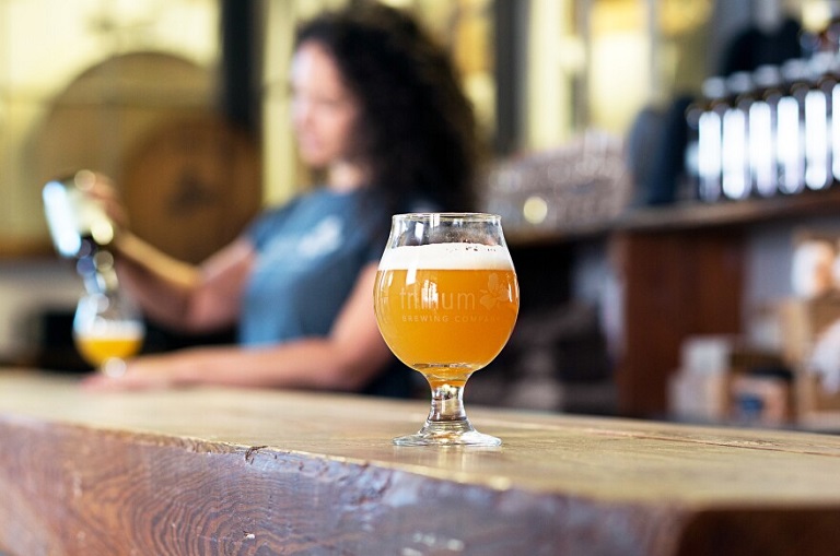 woman pouring hazy ipa beer in a bar 