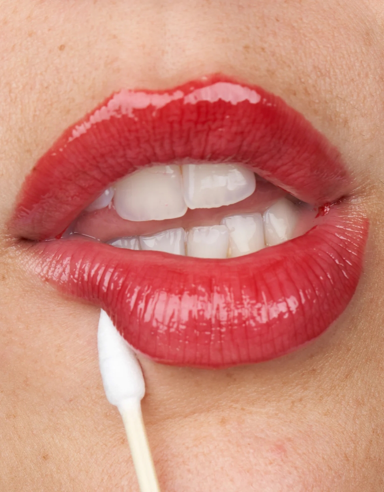 woman putting lip tint on her lips