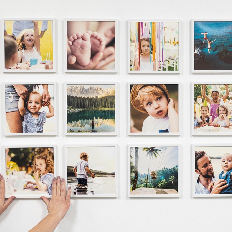 woman putting photo tiles on the wall