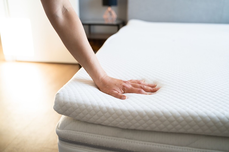 woman hand on a quality bed mattress