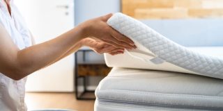 woman checking the new mattress on the bed