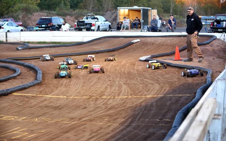 multiple remote control cars racing on an outdoor track